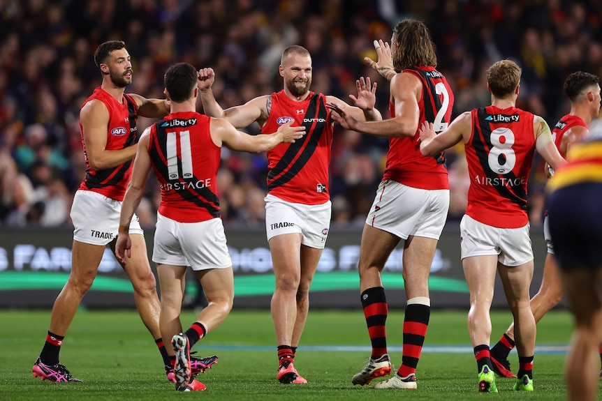 Jake Stringer celebrates with Essendon teammates