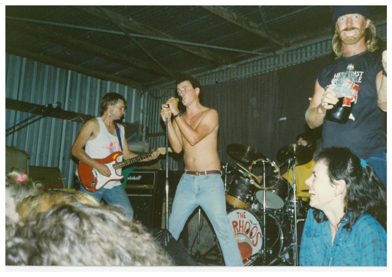 A singer performs on a shearing shed stage. 