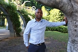 Tawanda Karasa stands next to a tree in a park in Brisbane on May 16, 2018.