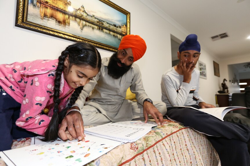 Sandeep teaching his daughter Jasmin and son Kanwardeep Punjabi language.