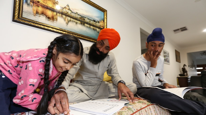 Sandeep teaching his daughter Jasmin and son Kanwardeep Punjabi language.