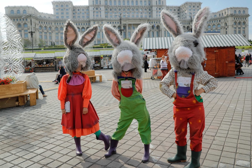 Entertainers in Romania wearing giant Rabbit heads stand outside the Romanian Parliament during the Easter fair in Bucharest.