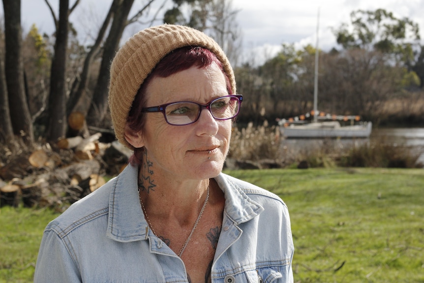 A woman smiles in a park