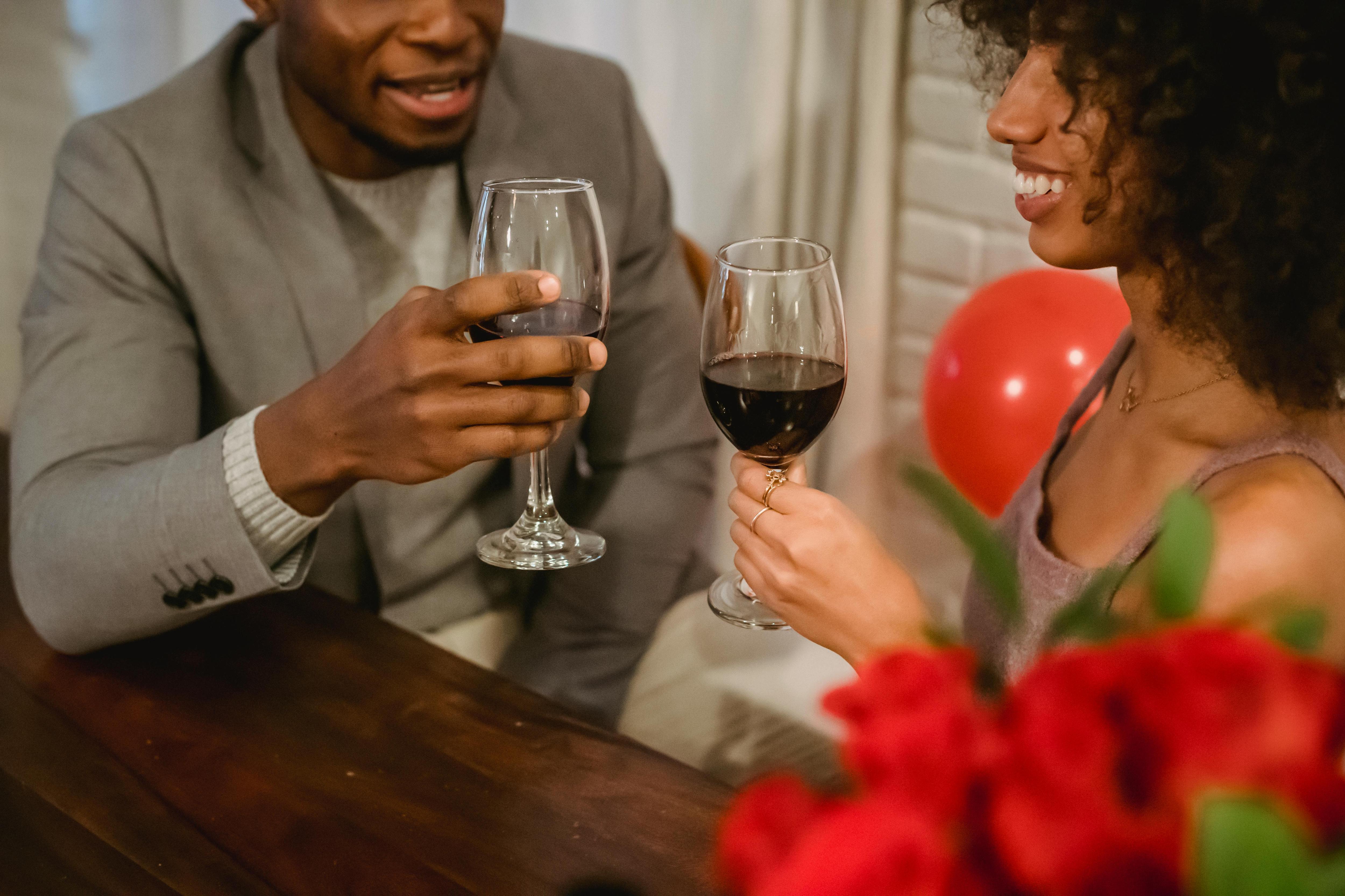 A couple toasting wine glasses at a table