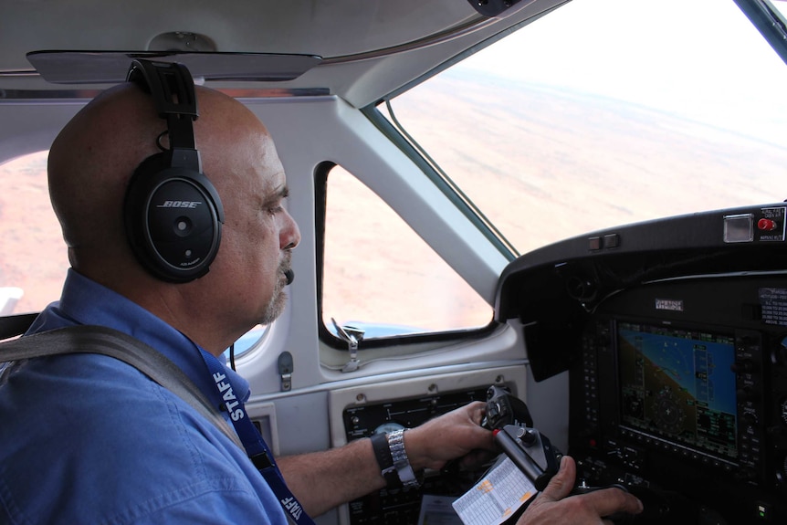 RFDS pilot Conrado Cialiero in the cockpit at the controls as his plane flies over outback NSW.