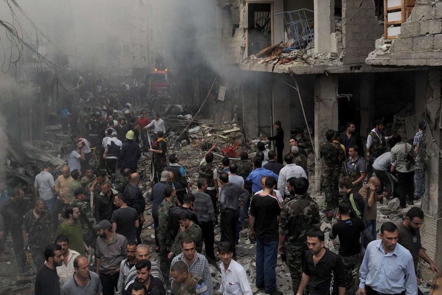 Syrians inspect the site of an explosion in the Mazzeh district of Damascus on November 5, 2012.