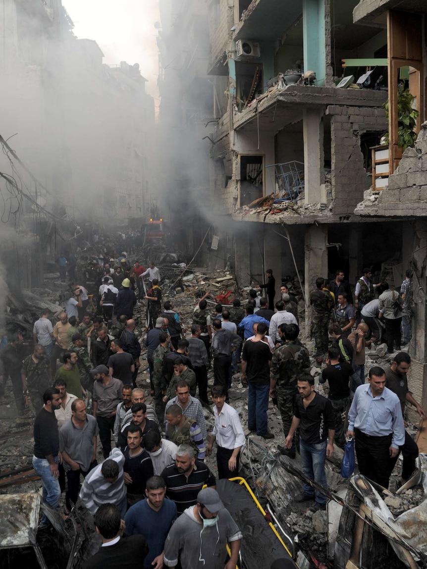 Syrians inspect the site of an explosion in the Mazzeh district of Damascus on November 5, 2012.