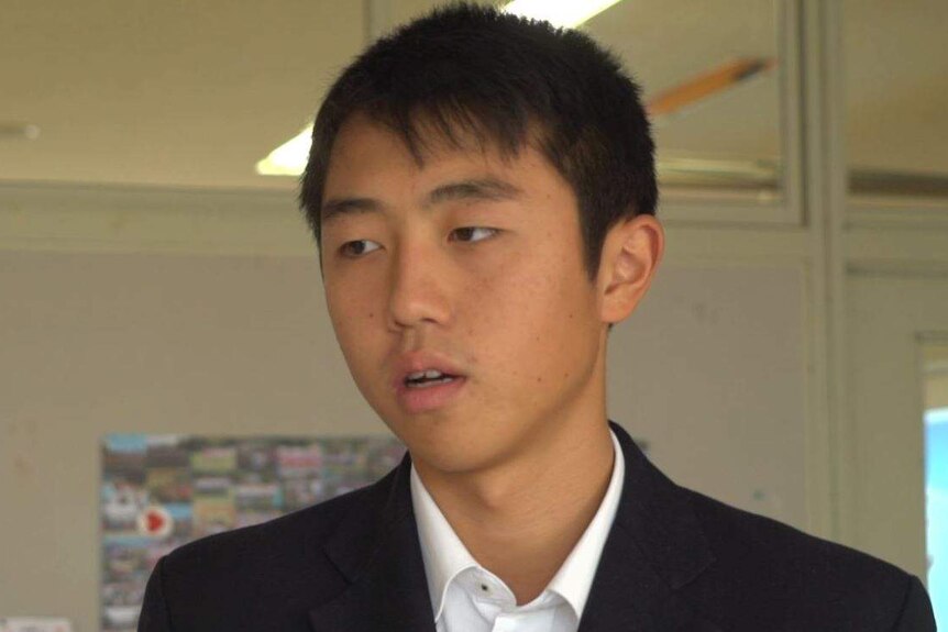 School student Ryong Chi Hyon talks as he looks away from the camera.