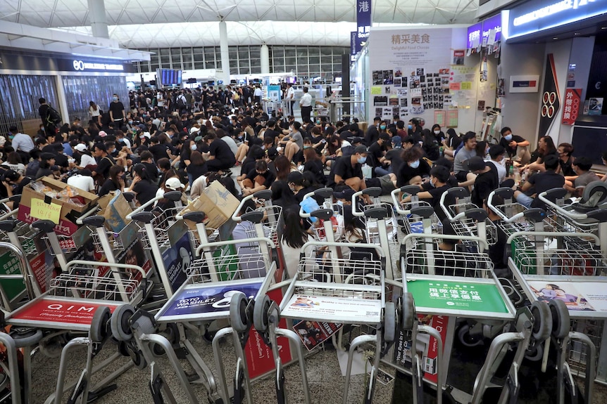 Protesters line up luggage trolleys to block departure gates.