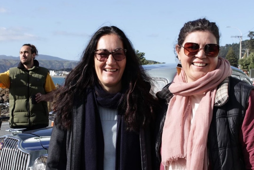 Two Maori women wearing warm clothing smile at the camera.