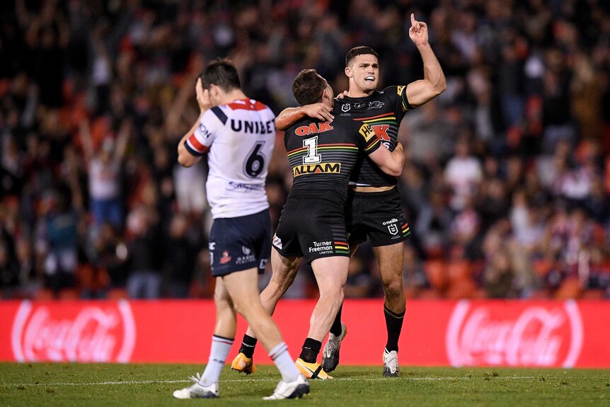 Penrith Panthers Nathan Cleary and Dylan Edwards celebrate a field goal as Luke Keary despairs.