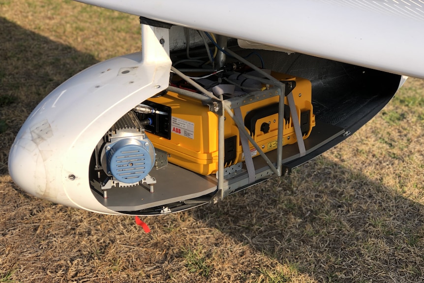 Une petite machine fixée sous l'aile d'un avion.