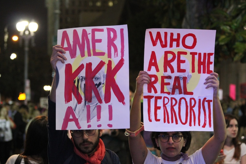 Protesters raise anti-racism posters at Trump demonstration in Downtown LA. November 10, 2016.