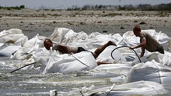 US Army National Guard troops work to build a barrier of giant sandbags against the BP oil spill offshore of Port Fourchon, L...