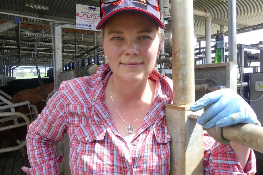 Female farmer in pink shirt looks at camera