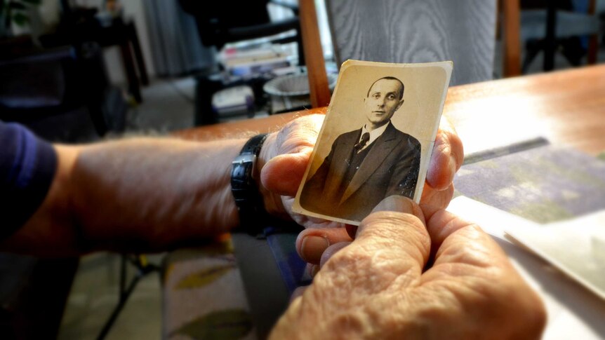 Andy Factor holds an old photo of his father, Charles.