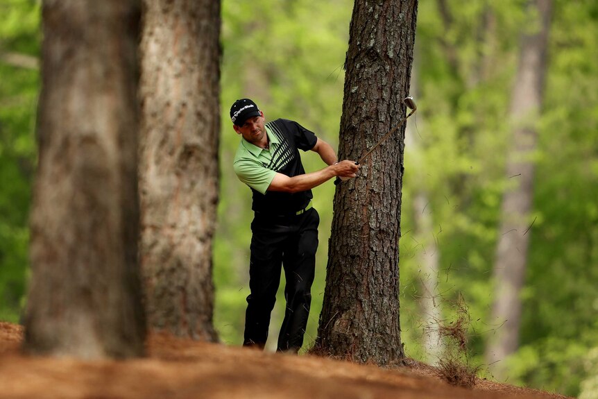 Tough spot ... Sergio Garcia hits his second shot on the 11th hole from the trees