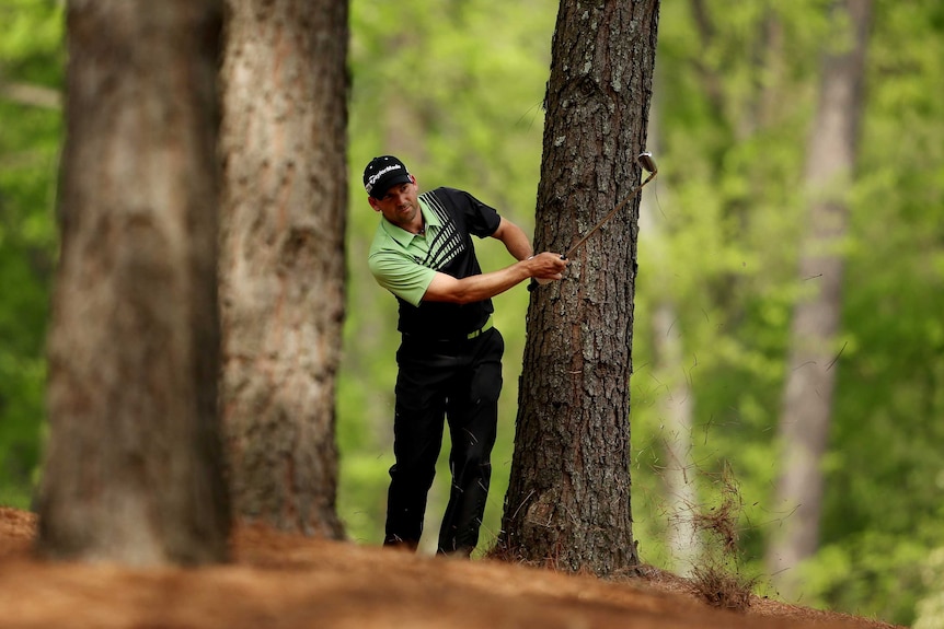 Tough spot ... Sergio Garcia hits his second shot on the 11th hole from the trees
