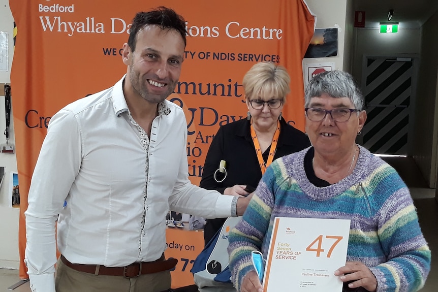 Man on left and woman with certificate on right