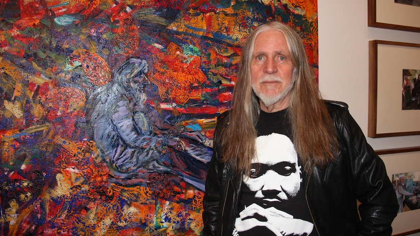 Artist George Gittoes with his painting “Bringing Heaven down to Earth”.