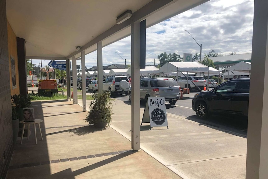 Heavy traffic at a border checkpoint, directly out the front of a small business.