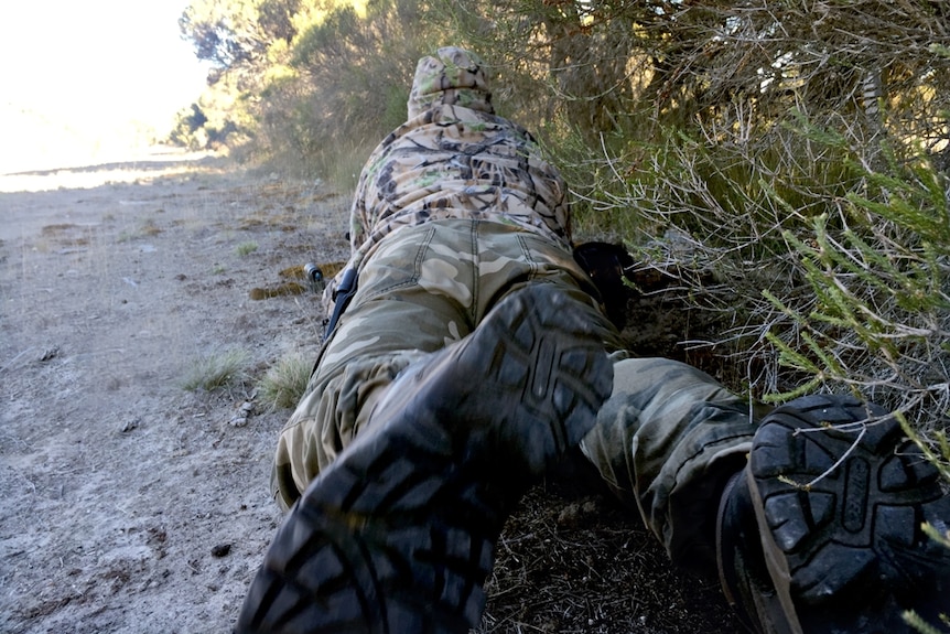 A hunter lies on the ground, South Australia, 2016