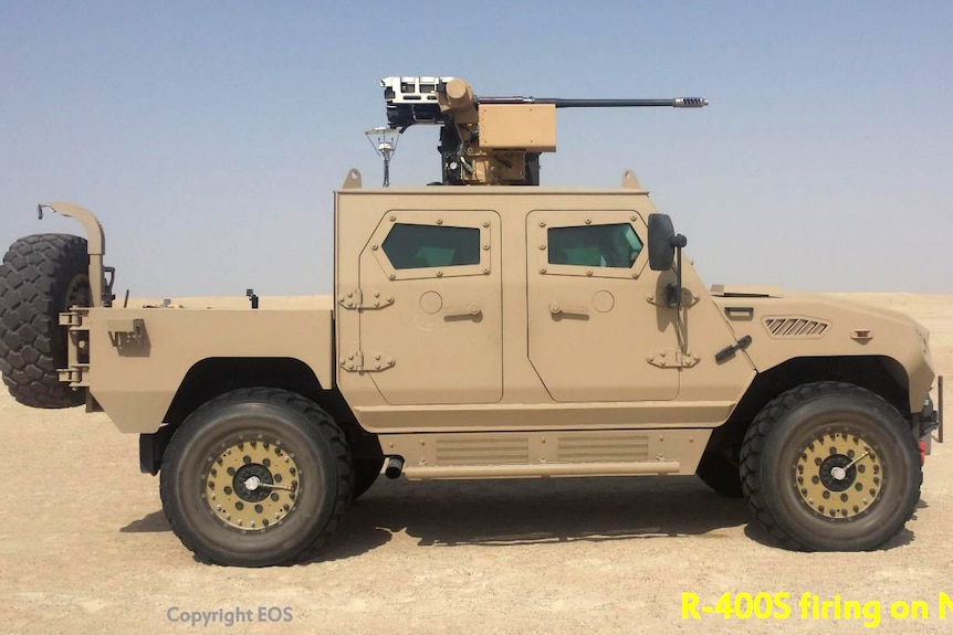 An armoured military vehicle with a large gun mounted on top, in the desert.