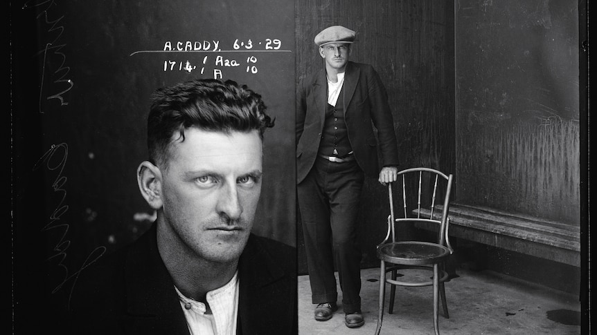 Side by side 1929 black and white mug shots of Arthur Caddy. Close up of Arthur's face and Arthur with hat, leaning on chair.