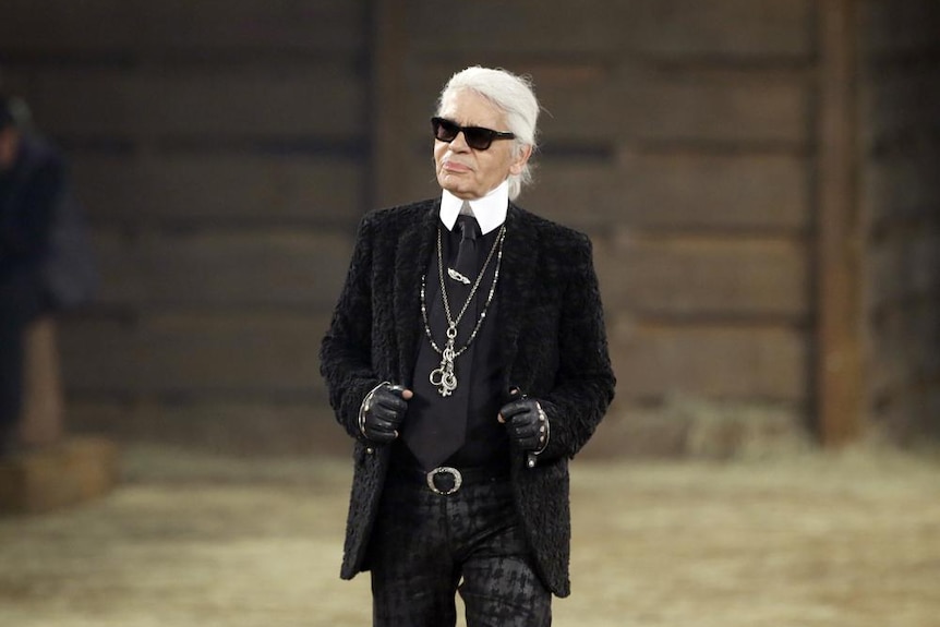 Designer Karl Lagerfeld stands on a runway for a fashion show