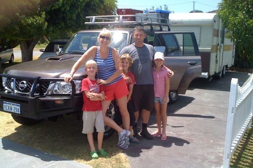 Mandy Farabegoli stands with her family in front of their car.