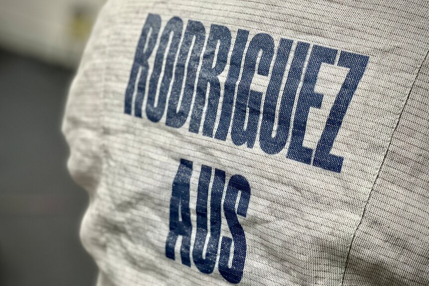 Close up of the back of a fencing jacket with the words Rodriguez, Aus.