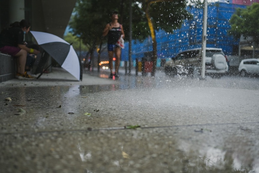 Rain falls in front of man running.