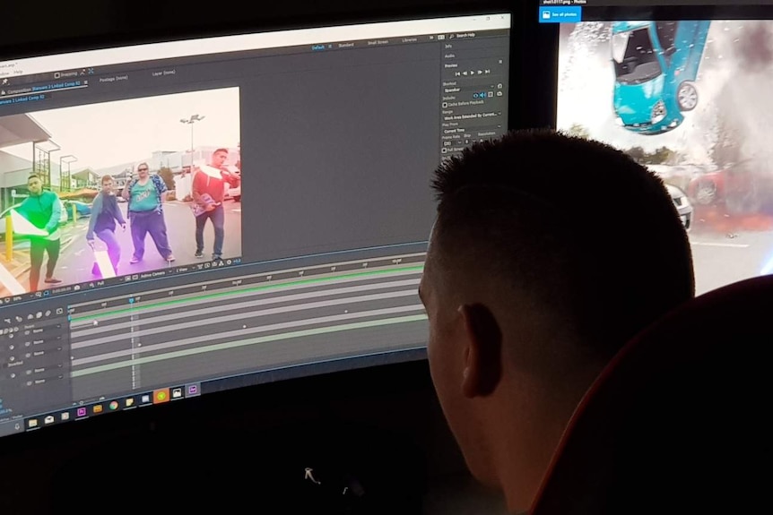A computer screen on which video footage is being edited by a seated man.