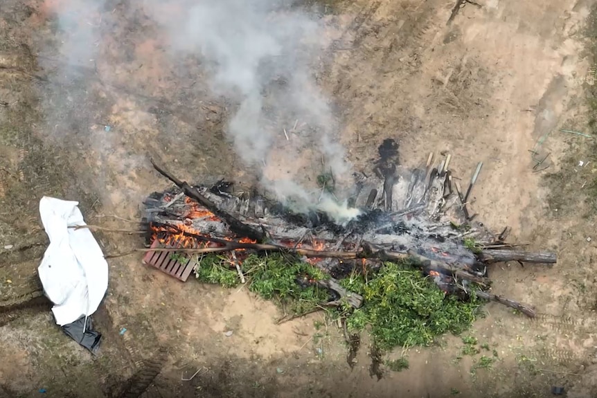 An aerial shot of crops burning on barren ground