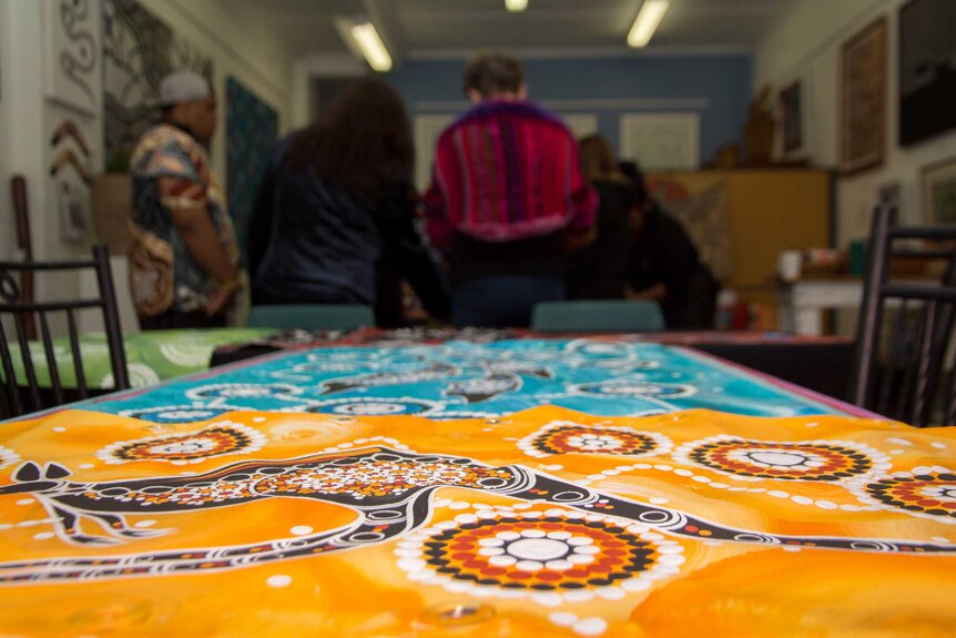 Indigenous artwork lies on a table.