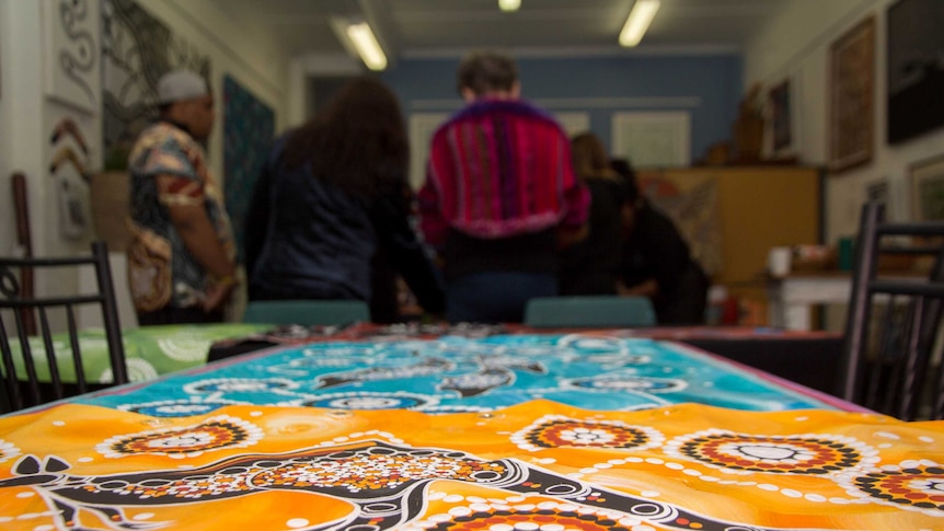 Indigenous artwork lies on a table.
