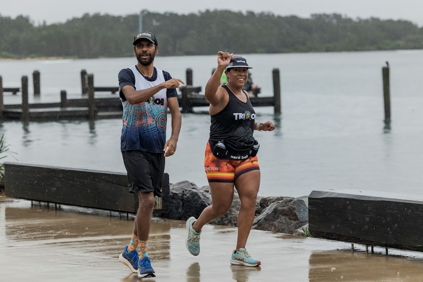 Two Indigenous athletes jogging while training for Ironman Australia.