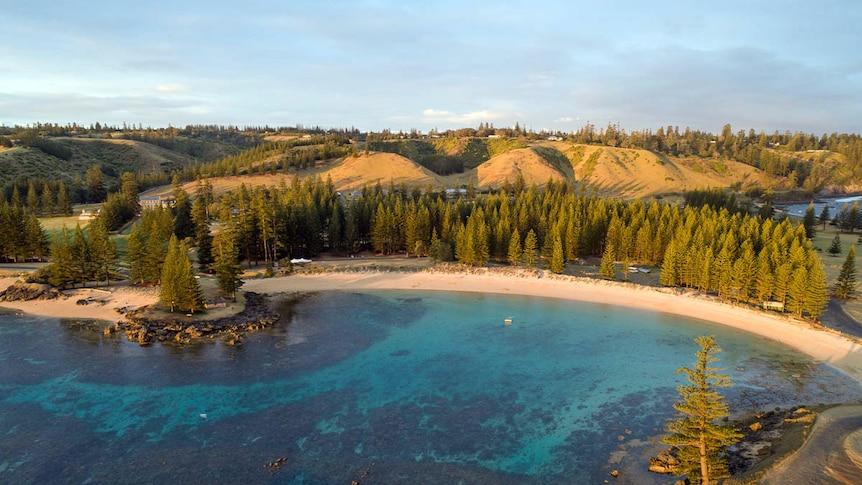 Aerial photo of Norfolk Island showcasing bright blue swimming bay called Emily Bay.
