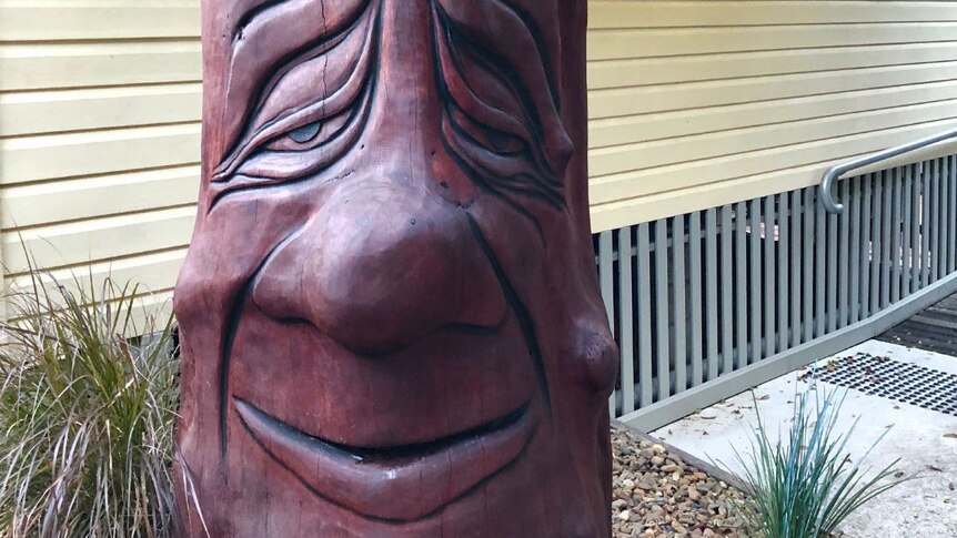 A tree trunk carved into the shape of a face