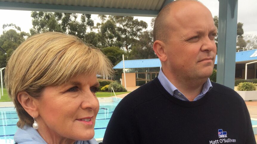 Julie Bishop stands with Matt O'Sullivan with a swimming pool in the background.