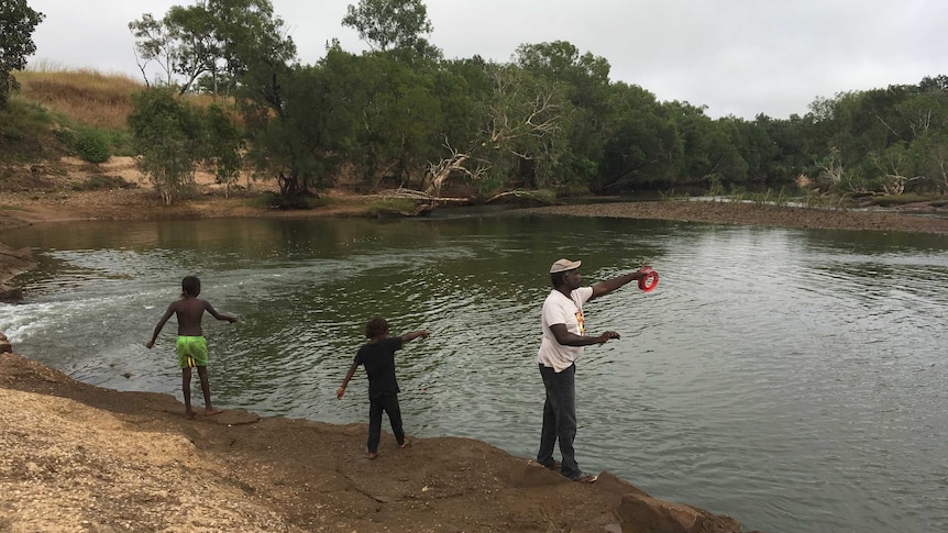 A man fishes with his children on the McArthur River near Borroloola in the NT.