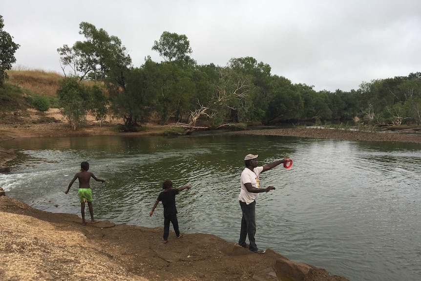 A man fishes with his children on the McArthur River near Borroloola in the NT.
