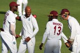 Roston Chase smiles and his hugged by three of his teammates