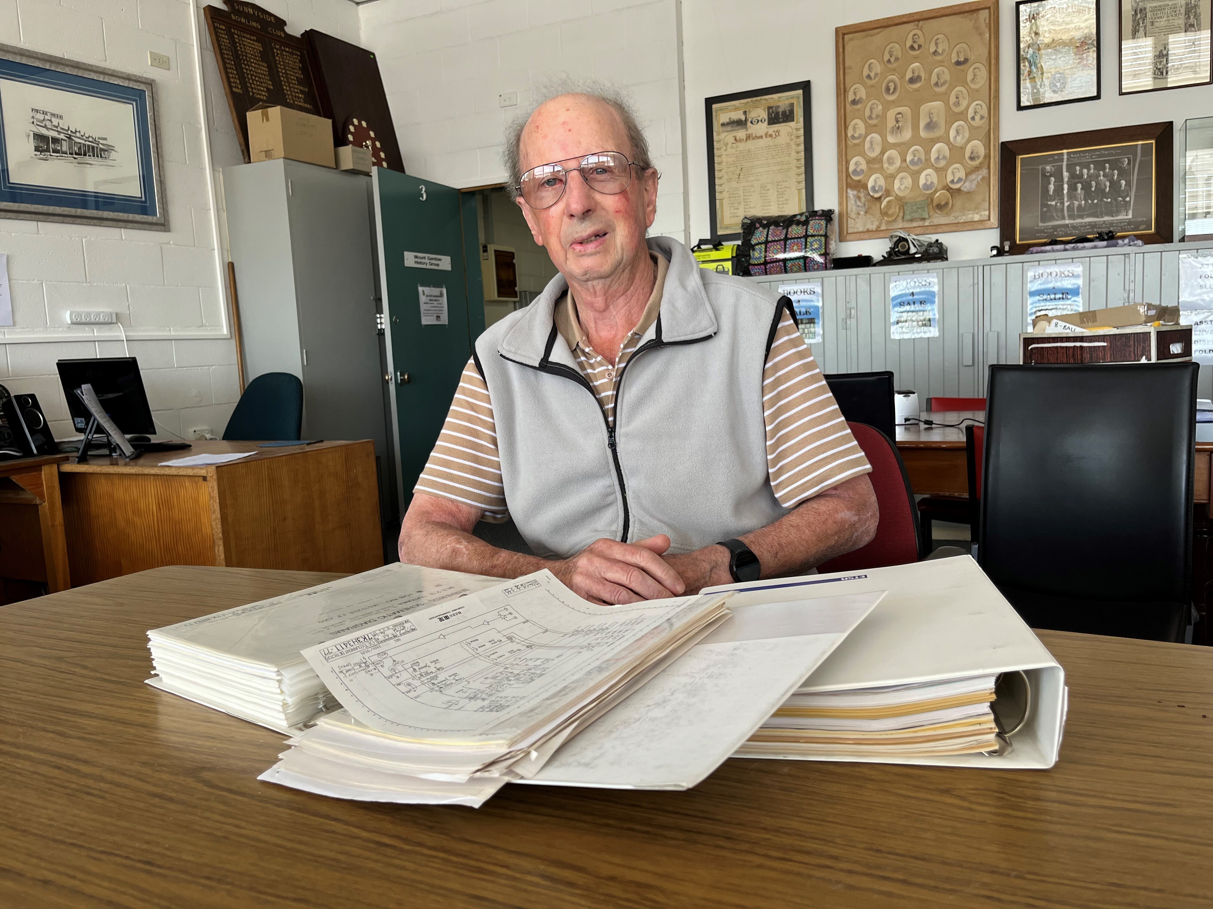 Un anciano mirando carpetas en una mesa