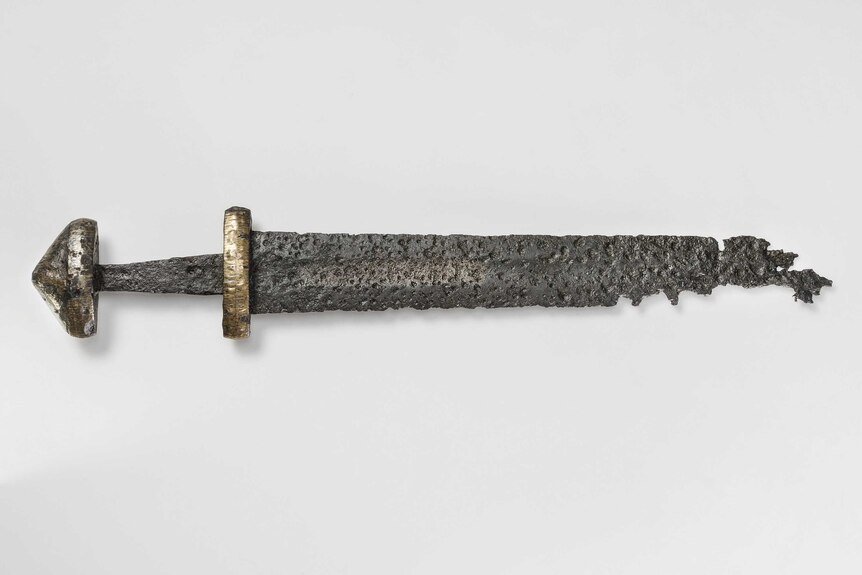 A double-edged iron sword from the Viking Age in Sweden. The hilt and pommel have overlays of thin bronze plates.