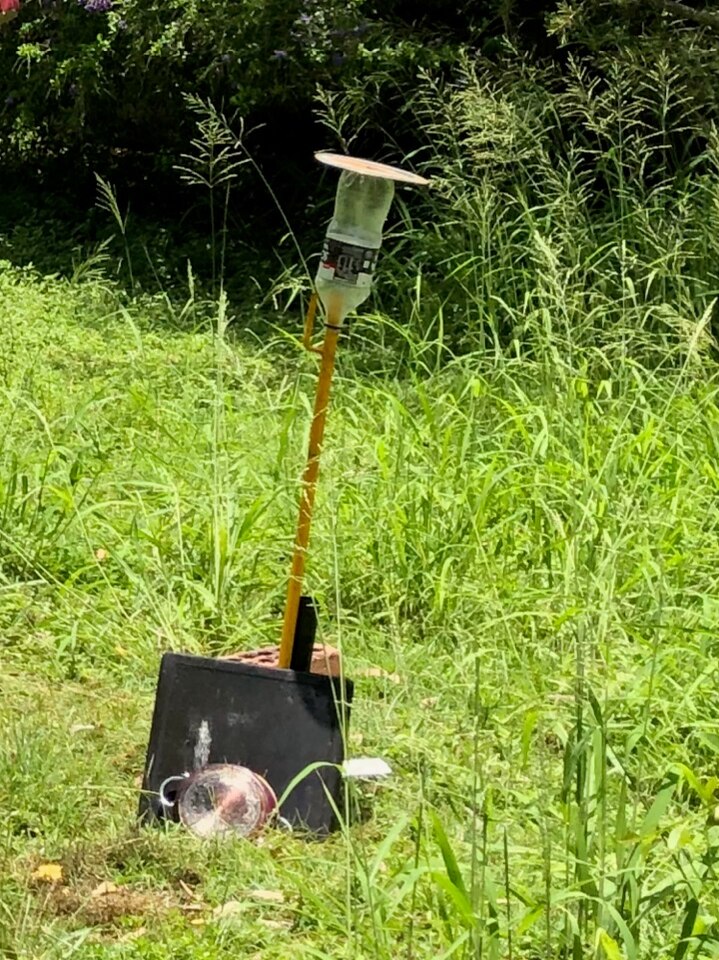 Homemade rocket set up for launch in the home's backyard.
