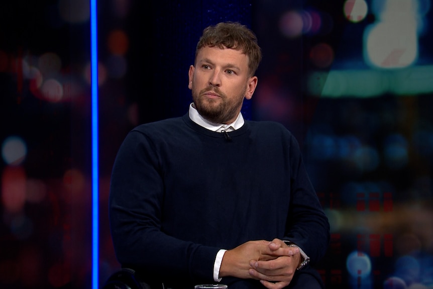 Man on a panel show speaking.