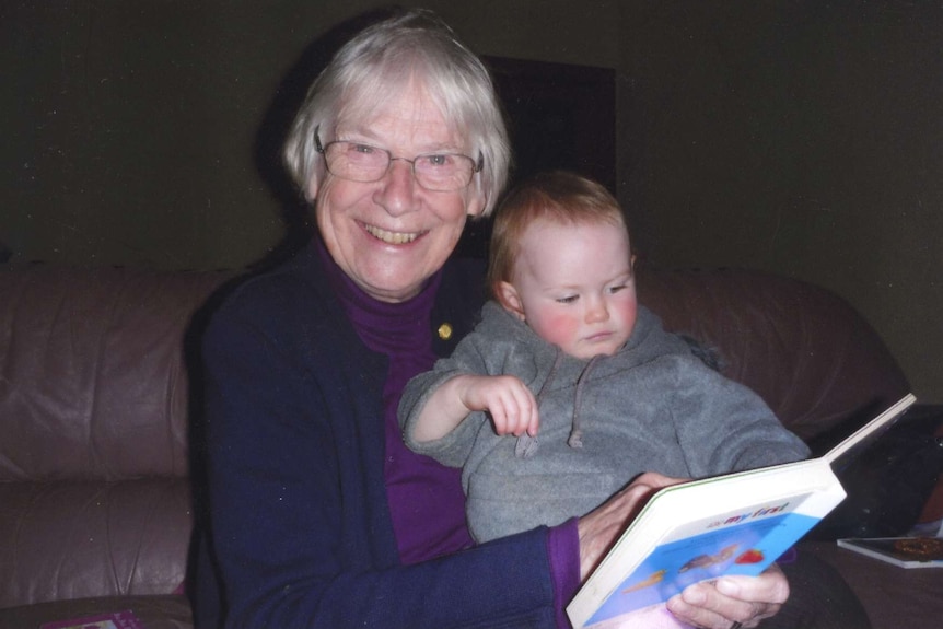 An older woman holding a baby
