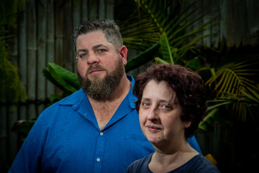 A man in a blue shirt behind a woman