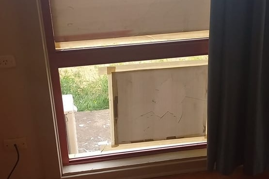 A window with covering over the glass where a rock has been thrown through.
